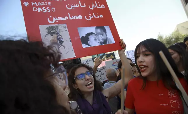 Members of the opposition and civil society groups shout slogans and wave placards during a demonstration against Tunisia president Kais Saied, ahead of the upcoming presidential elections, in Tunis, Friday, Sept. 27, 2024. Banner in Arabic reads: "We will not forgive, we will not forget." (AP Photo/Anis Mili)