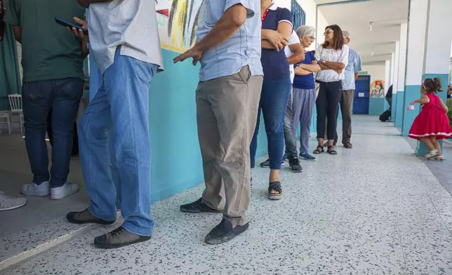 Voters queue to cast their ballot outside a polling station during the presidential elections, in the capital Tunis, Tunisia, Sunday, Oct. 6, 2024 (AP Photo/Ons Abid)