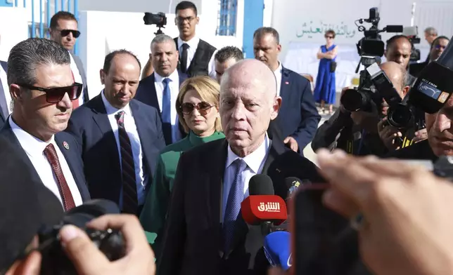 Tunisian President and candidate for re-election Kais Saied, center, and his wife Ichraf Chebil Saïed, leave a polling station after casting their votes, in Tunis, Tunisia, Sunday, Oct. 6, 2024 (AP Photo/Anis Mili)