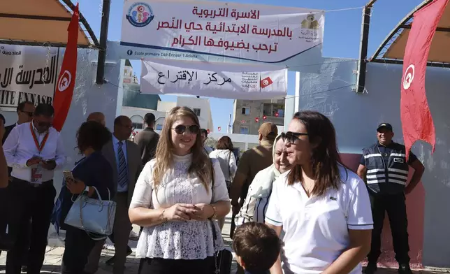 Voters and officials gather outside a polling station during the presidential elections, in the capital Tunis, Tunisia, Sunday, Oct. 6, 2024. (AP Photo/Anis Mili)