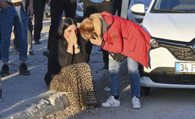 People gather outside of Turkish Aerospace Industries Inc. at the outskirts of Ankara, Turkey, Wednesday, Oct. 23, 2024. (AP Photo/Mert Gokhan Koc)