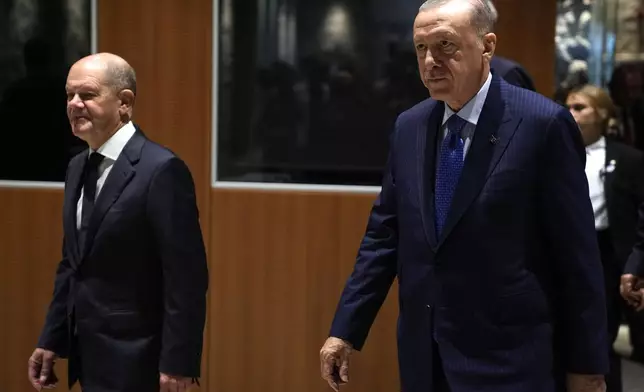 Turkey's President Recep Tayyip Erdogan, right, and Germany's Chancellor Olaf Scholz, arrive to hold a presser in Istanbul, Turkey, Saturday, Oct. 19, 2024. (AP Photo/Khalil Hamra)