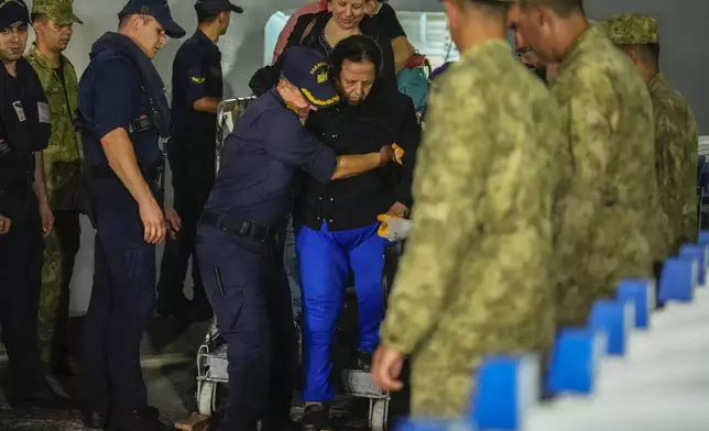 People mostly Turkish nationals disembark from Turkish TCG Sancaktar military ship after being evacuated from Lebanon's capital Beirut to Turkey, in Mersin port, southern Turkey, early Friday, Oct. 11, 2024. (AP Photo/Emrah Gurel)