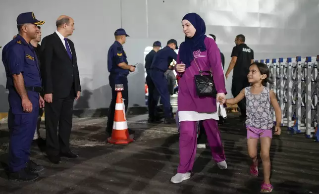 People, mostly Turkish nationals, disembark from Turkish TCG Sancaktar military ship after being evacuated from Lebanon's capital Beirut to Turkey, in Mersin port, southern Turkey, early Friday, Oct. 11, 2024. (AP Photo/Emrah Gurel)