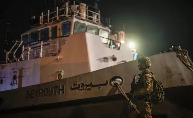 A Turkish security personnel stands guard next to Turkish military ships preparing to evacuate citizens from Lebanon to Turkey, in Beirut port, Wednesday, Oct. 9, 2024. (AP Photo/Emrah Gurel)