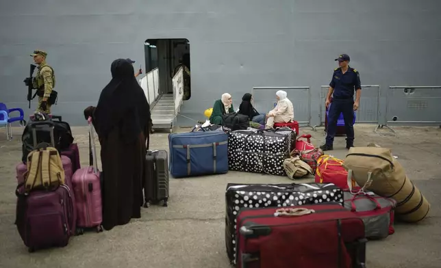 People, mostly Turkish citizens, wait to go on board of a Turkish military ship evacuating them from Lebanon to Turkey, in Beirut port, on Thursday, Oct. 10, 2024. (AP Photo/Emrah Gurel)