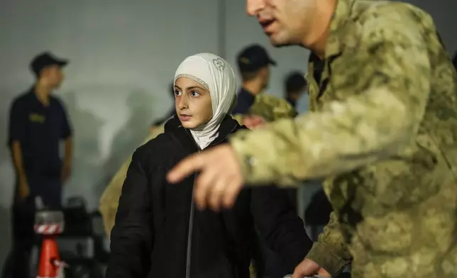 People, mostly Turkish nationals, disembark from Turkish TCG Sancaktar military ship after being evacuated from Lebanon's capital Beirut to Turkey, in Mersin port, southern Turkey, early Friday, Oct. 11, 2024. (AP Photo/Emrah Gurel)