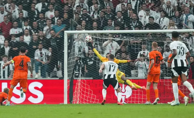 Eintracht Frankfurt's goalkeeper Kaua Santos, background, blocks a shot by Besiktas' Rafa Silva during to the Europa League opening phase soccer match between Besiktas and Eintracht Frankfurt at the Besiktas stadium in Istanbul, Turkey, Thursday, Oct. 3, 2024. (AP Photo/Khalil Hamra)