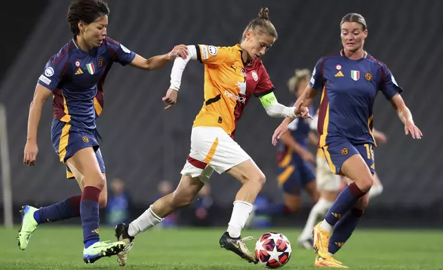 Galatasaray's Ebru Topcu, center, fights for the ball with Roma's Saki Kumagai, left, and Verena Hanshaw during the women's Champions League group A soccer match between Galatasaray and Roma at Ataturk Olympic stadium in Istanbul, Turkey, Thursday, Oct. 17, 2024. (Huseyin Yavuz/Dia Photo via AP)