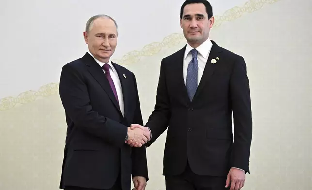 Russian President Vladimir Putin, left, and Turkmenistan's President Serdar Berdimuhamedov shake hands during their meeting on the sidelines of the International Forum "The Interconnection of Times and Civilizations – the basis of peace and development" dedicated to the 300th anniversary of the birth of the outstanding Turkmen poet and thinker Magtymguly Fragi in Ashgabat, Turkmenistan, Friday, Oct. 11, 2024. (Sergei Bobylev, Sputnik, Kremlin Pool Photo via AP)