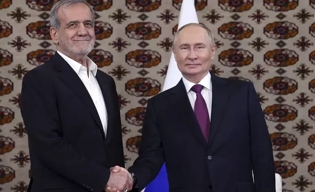 Russian President Vladimir Putin, right, and Iranian President Masoud Pezeshkian pose for a photo during their meeting on the sidelines of the International Forum "The Interconnection of Times and Civilizations – the basis of peace and development" dedicated to the 300th anniversary of the birth of the outstanding Turkmen poet and thinker Magtymguly Fragi in Ashgabat, Turkmenistan, Friday, Oct. 11, 2024. (Alexander Shcherbak, Sputnik, Kremlin Pool Photo via AP)