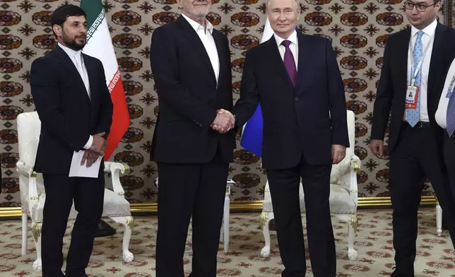 Russian President Vladimir Putin, center right, and Iranian President Masoud Pezeshkian, center left, shake hands during their meeting on the sidelines of the International Forum "The Interconnection of Times and Civilizations – the basis of peace and development" dedicated to the 300th anniversary of the birth of the outstanding Turkmen poet and thinker Magtymguly Fragi in Ashgabat, Turkmenistan, Friday, Oct. 11, 2024. (Sputnik, Kremlin Pool Photo via AP)