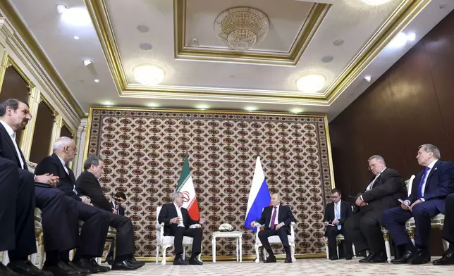 Russian President Vladimir Putin, background right, listens to Iranian President Masoud Pezeshkian, background left, during their meeting on the sidelines of the International Forum "The Interconnection of Times and Civilizations – the basis of peace and development" dedicated to the 300th anniversary of the birth of the outstanding Turkmen poet and thinker Magtymguly Fragi in Ashgabat, Turkmenistan, Friday, Oct. 11, 2024. (Alexander Shcherbak, Sputnik, Kremlin Pool Photo via AP)