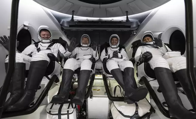 This photo provided by NASA shows Roscosmos cosmonaut Alexander Grebenkin, left, NASA astronauts Michael Barratt, second from left, Matthew Dominick, second from right, and Jeanette Epps, right, inside the SpaceX Dragon Endeavour spacecraft onboard the SpaceX recovery ship MEGAN shortly after having landed in the Gulf of Mexico off the coast of Pensacola, Florida, Friday, Oct. 25, 2024. (NASA/Joel Kowsky via AP)