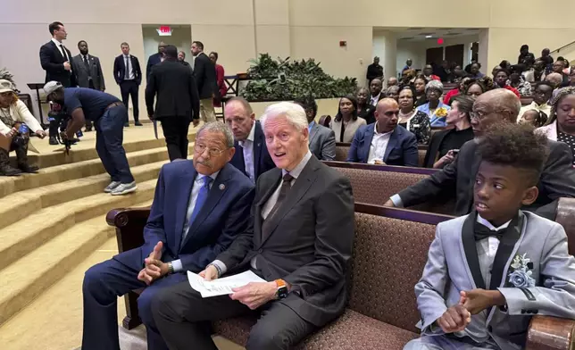 Former President Bill Clinton and U.S. Congressman Sanford Bishop talk at Mt. Zion Baptist Church in Albany, Ga. on Sunday, Oct. 13, 2024. (AP Photo/Charlotte Kramon)