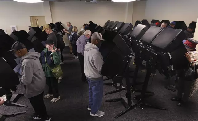 Voters cast their ballots during the first day of in person early voting at the Franklin County Board of Elections in Columbus, Ohio, Tuesday, Oct. 8, 2024. (AP Photo/Paul Vernon)