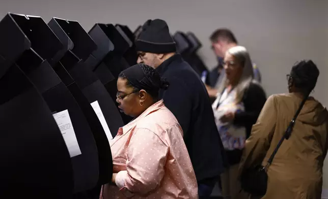 Voters cast their ballots during the first day of in person early voting at the Franklin County Board of Elections in Columbus, Ohio, Tuesday, Oct. 8, 2024. (AP Photo/Paul Vernon)