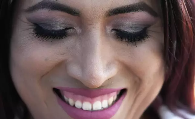 Julieth Luna Garcia, a transgender woman from El Salvador, smiles as she listens to Drew Heckman from Rainbow Railroad at Horner Park in Chicago, Monday, Sept. 30, 2024. (AP Photo/Nam Y. Huh)