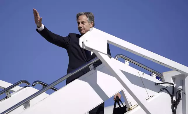 Secretary of State Antony Blinken waves as he boards a plane en route to the Middle East as he departs Joint Base Andrews, Md., Monday, Oct. 21, 2024. (Nathan Howard/Pool Photo via AP)