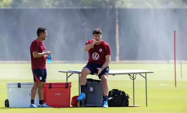 United States coach Mauricio Pochettino, right, and first assistant coach, Jesus Perez, wait for the team to join the pitch before practice, Friday, Oct. 11, 2024, in Austin, Texas, as the U.S. men's national soccer team prepares play Panama in an international friendly on Saturday. (AP Photo/Rodolfo Gonzalez)