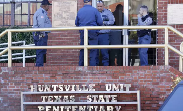 Prison staff gather at the main entrance of the building housing the execution chamber as Robert Roberson awaits his execution, at the Huntsville Unit of the Texas State Penitentiary, Thursday, Oct. 17, 2024, in Huntsville, Texas. (AP Photo/Michael Wyke)