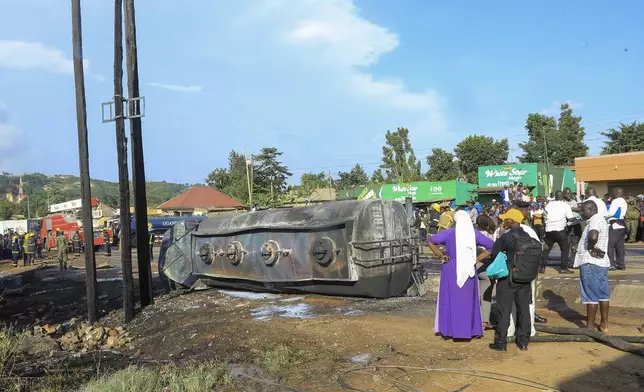 People gather near the site where a fuel truck exploded, next to a highway on the outskirts of Kampala, Uganda, Tuesday, Oct. 22, 2024. (AP Photo)