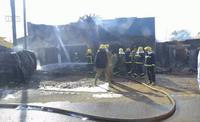 Firefighters try to contain a fire after a fuel truck exploded next to a highway on the outskirts of Kampala, Uganda, Tuesday, Oct. 22, 2024. (AP Photo)