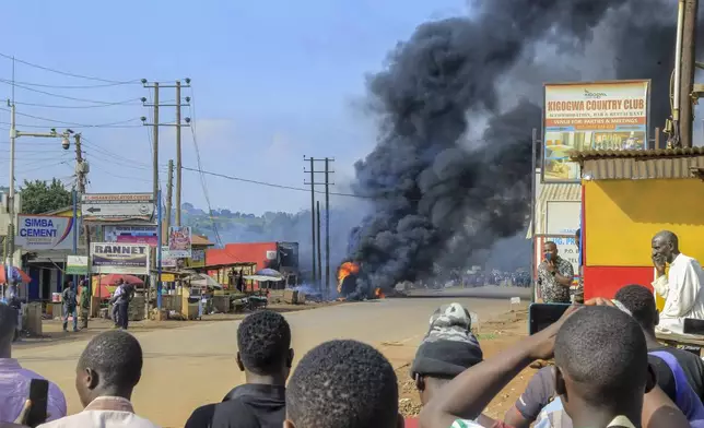 People gather near the site where a fuel truck exploded, next to a highway on the outskirts of Kampala, Uganda, Tuesday, Oct. 22, 2024. (AP Photo)