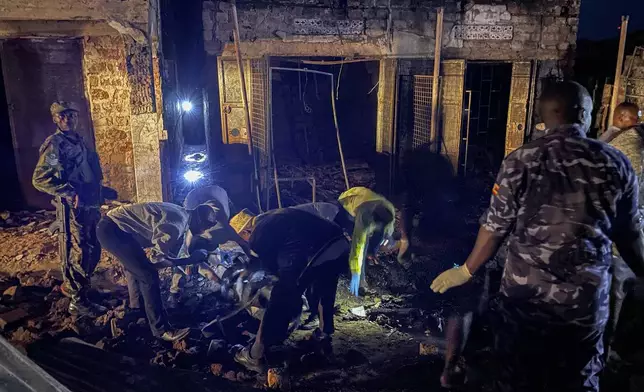 Uganda forensic officials inspect the site where a fuel truck exploded, on the outskirts of Kampala, Uganda, Tuesday, Oct. 22, 2024. (AP Photo)