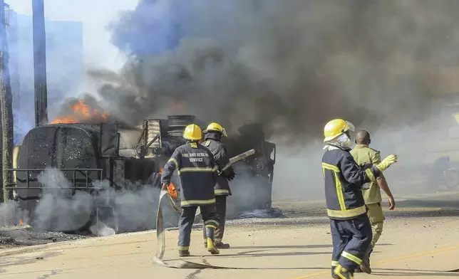 Firefighters try to contain a fire after a fuel truck exploded next to a highway on the outskirts of Kampala, Uganda, Tuesday, Oct. 22, 2024. (AP Photo)