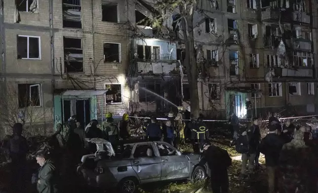 Rescue workers clear the rubble of a building damaged by a Russian airstrike in Kharkiv, Ukraine, Wednesday Oct. 2, 2024. (AP Photo/Yevhen Titov)