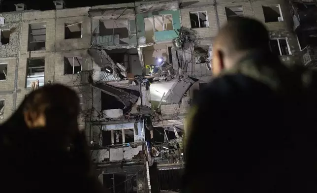 Rescue workers clear the rubble inside a building damaged by a Russian airstrike in Kharkiv, Ukraine, Thursday Oct. 3, 2024. (AP Photo/Yevhen Titov)