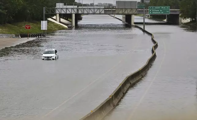 FILE - A vehicle is stranded in high waters on a flooded highway at Interstate 10 and Washington in Houston, on Monday, July 8, 2024, after Hurricane Beryl came ashore. (AP Photo/Maria Lysaker, File)