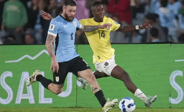 Uruguay's Nahitan Nandez, left, and Ecuador's Alan Minda compete for the ball during a FIFA World Cup 2026 qualifying soccer match at the Centenario stadium in Montevideo, Uruguay, Tuesday, Oct. 15, 2024. (AP Photo/Matilde Campodonico)