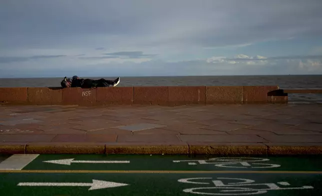 A man rests the wall of a promenade ahead of Sunday's general election, in Montevideo, Uruguay, Friday, Oct. 25, 2024. (AP Photo/Natacha Pisarenko)