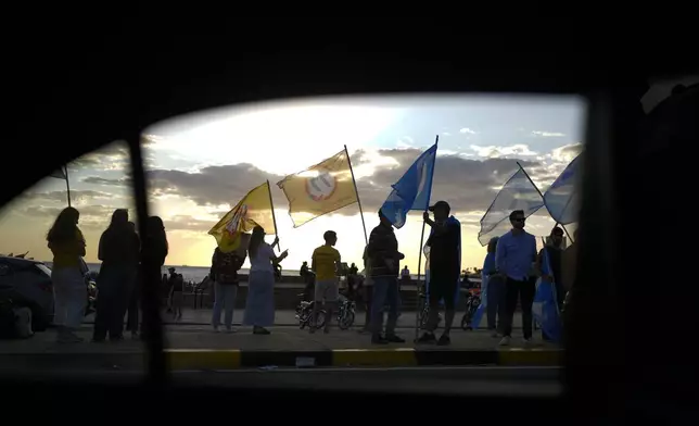 Political party members rally a day ahead of the general election, in Montevideo, Uruguay, Saturday, Oct. 26, 2024. (AP Photo/Natacha Pisarenko)