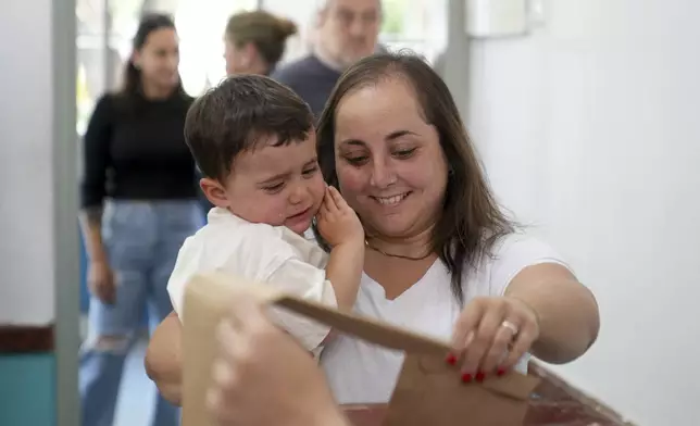 A woman votes during general elections in Canelones, Uruguay, Sunday, Oct. 27, 2024. (AP Photo/Matilde Campodonico)