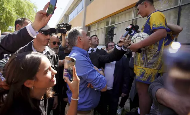 Frente Amplio presidential candidate Yamandu Orsi, center, talks to a youth after voting in general elections in Canelones, Uruguay, Sunday, Oct. 27, 2024. (AP Photo/Matilde Campodonico)