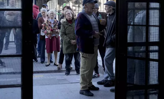 People line up to vote outside a polling station during general elections in Montevideo, Uruguay, Sunday, Oct. 27, 2024. (AP Photo/Natacha Pisarenko)