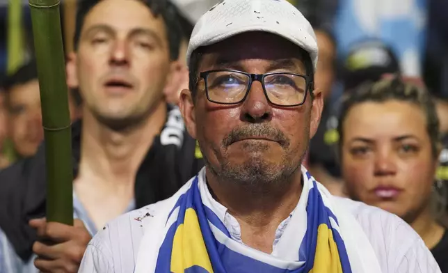 A supporter of Alvaro Delgado, presidential candidate for the ruling National Party, attends a rally six days ahead of presidential elections, in Maldonado, Uruguay, Monday, Oct. 21, 2024. (AP Photo/Matilde Campodonico)