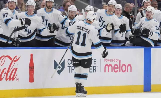 Utah Hockey Club's Dylan Guenther (11) celebrates with teammates after scoring during the third period of an NHL hockey game against the New York Islanders Thursday, Oct. 10, 2024, in Elmont, N.Y. (AP Photo/Frank Franklin II)