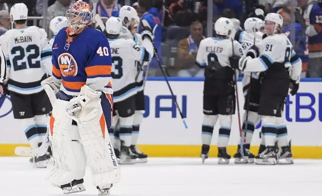 New York Islanders goaltender Semyon Varlamov (40) leaves the ice as the Utah Hockey Club celebrate after an NHL hockey game Thursday, Oct. 10, 2024, in Elmont, N.Y. (AP Photo/Frank Franklin II)