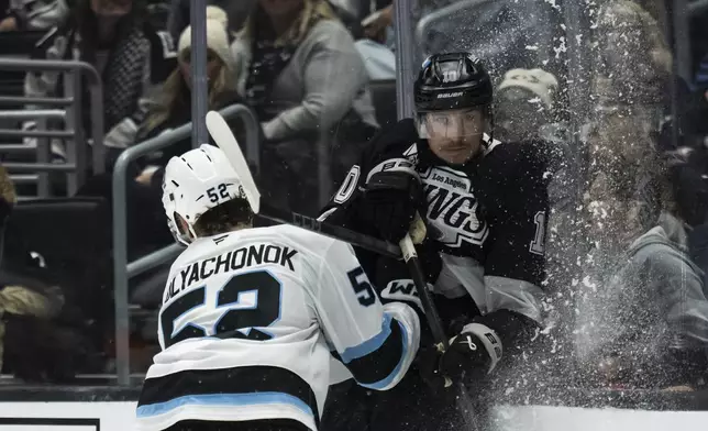 Utah Hockey Club defenseman Vladislav Kolyachonok (52) checks Los Angeles Kings left wing Tanner Jeannot (10) during the second period of an NHL hockey game, Saturday, Oct. 26, 2024, in Los Angeles. (AP Photo/Kyusung Gong)