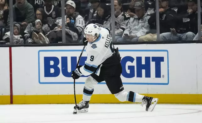 Utah Hockey Club center Clayton Keller (9) shoots for a goal during the second period of an NHL hockey game against the Los Angeles Kings, Saturday, Oct. 26, 2024, in Los Angeles. (AP Photo/Kyusung Gong)