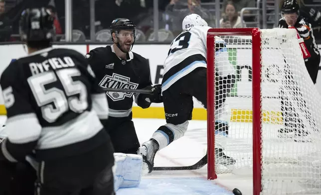 Los Angeles Kings defenseman Joel Edmundson (6) scores a goal past Utah Hockey Club left wing Matias Maccelli (63) during the second period of an NHL hockey game, Saturday, Oct. 26, 2024, in Los Angeles. (AP Photo/Kyusung Gong)