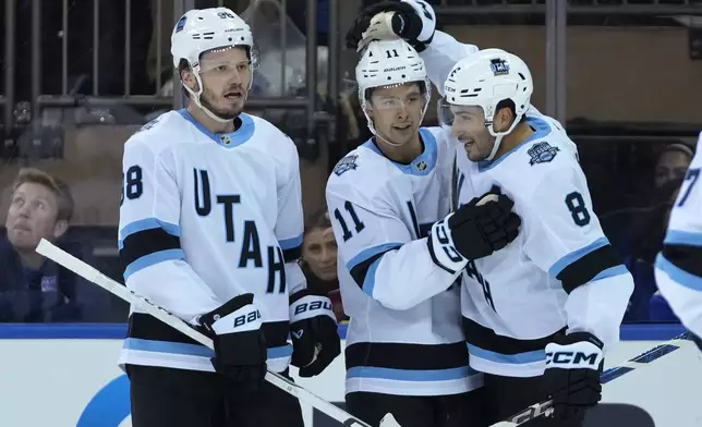 Utah Hockey Club's Mikhail Sergachev, left, Dylan Guenther, center, and Nick Schmaltz, right, celebrate after Guenther scored during the second period of an NHL hockey game against the New York Rangers, Saturday, Oct. 12, 2024, in New York. (AP Photo/Pamela Smith)