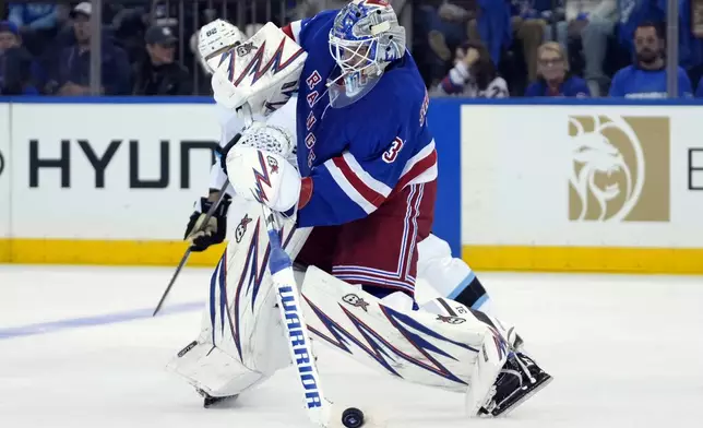 New York Rangers' Igor Shesterkin skates with the puck during the second period of an NHL hockey game against the Utah Hockey Club, Saturday, Oct. 12, 2024, in New York. (AP Photo/Pamela Smith)