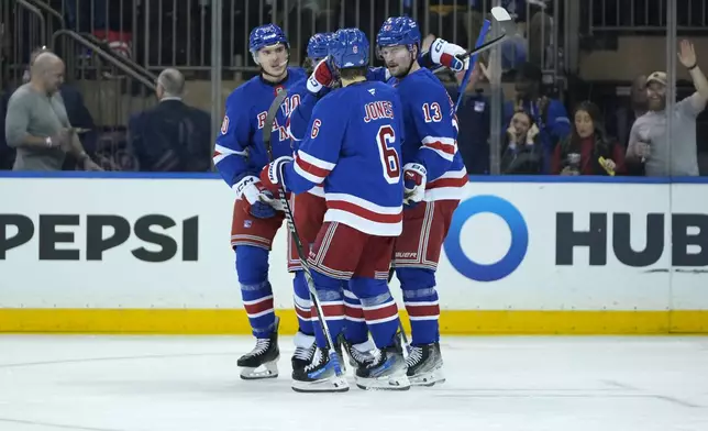 New York Rangers players celebrate after Artemi Panarin scored during the first period of an NHL hockey game against the Utah Hockey Club, Saturday, Oct. 12, 2024, in New York. (AP Photo/Pamela Smith)