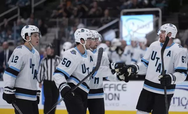 Utah Hockey Club defenseman Sean Durzi (50) celebrates with Lawson Crouse, right, after scoring a goal during the second period of a pre-season NHL hockey game against the San Jose Sharks, Tuesday, Oct. 1, 2024, in San Jose, Calif. (AP Photo/Godofredo A. Vásquez)