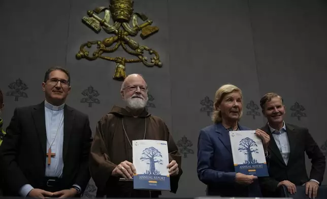 From left, Monsignior Luis Herrera, Cardinal Sean Patrick O' Malley, jurist Maud de Boer-Buquicchio and clergy sex abuse survivor and victim's advocate Juan Carlos Cruz, pose for a photo at the end of a press conference to present the Vatican's first Annual Global Report on Minors Protection at the Vatican press center, Tuesday, Oct. 29, 2024. (AP Photo/Alessandra Tarantino)